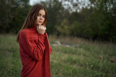 Dışarıda kırmızı kazaklı bir kadın var.