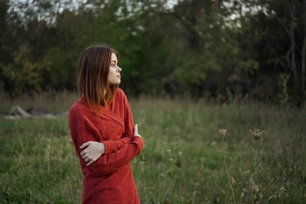 Γυναίκα σε ένα κόκκινο πουλόβερ σε εξωτερικούς χώρους στον τομέα της φύσης υπόλοιπο — Φωτογραφία Αρχείου