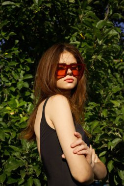 Siyah mayo giyen kadın güneş gözlüğü takıyor.