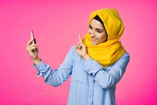 一个快乐的女人，头戴黄色头巾，手里拿着电话，通信技术 — 图库照片