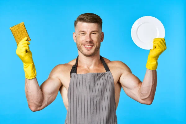 围裙清洁洗碗蓝色背景的男人 — 图库照片