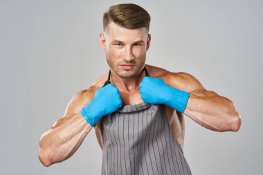 Önlüklü şişmiş adam lastik eldiven giymiş, daha temiz poz veriyor.