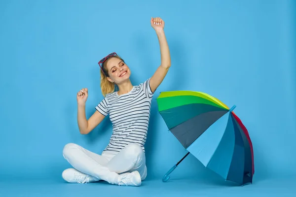Bonita mulher moda posando colorido guarda-chuva azul fundo — Fotografia de Stock
