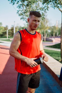 Sportif adam yedek kulübesinde oturuyor.