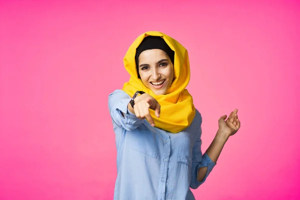 穿着黄色头巾的快乐女人电子手表技术用户粉色背景 — 图库照片