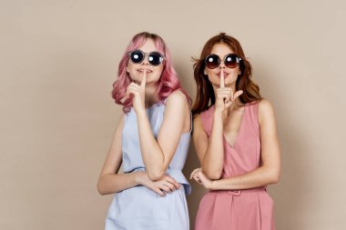 Moda elbiseli iki bayan arkadaş aksesuar stüdyosunun yanında duruyor.