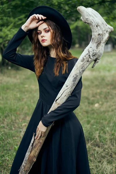 Kvinna i svart häxa kostym i skogen natur poserar — Stockfoto