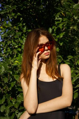 Siyah mayo giyen kadın güneş gözlüğü takıyor.