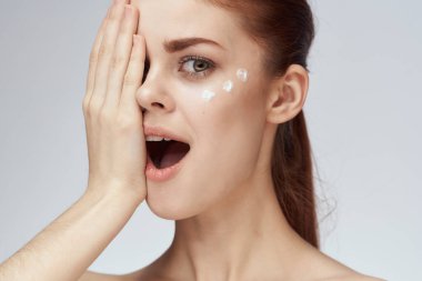 Çıplak omuzlu kadın yüz kremi cilt bakımına yakın çekim