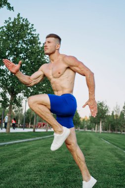 Parkta vücut egzersizi yapan atletik bir adam.