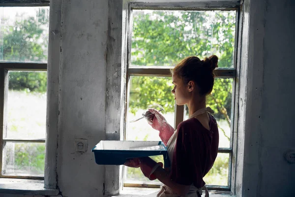 Kvinna målar fönster i huset inredning rum renovering — Stockfoto