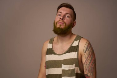 Kollarında dövmeleri olan yakışıklı bir adam. Saç stili duyguları var.