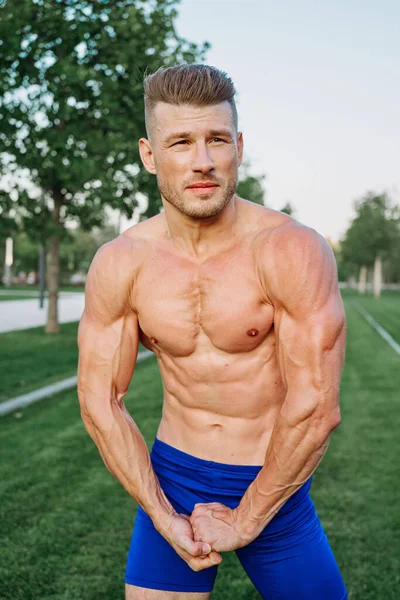 Deportista musculoso hombre con torso desnudo en un parque de entrenamiento — Foto de Stock