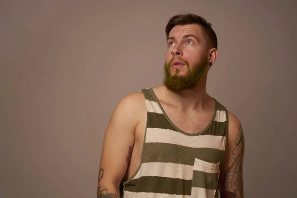 National bearded man in a striped jersey hipster tattoos on his arms — Stock Photo, Image