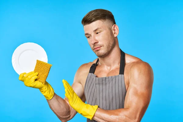 A man with a pumped-up body wearing rubber gloves doing homework — Stock Photo, Image