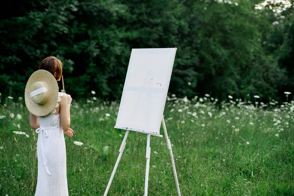 Žena v bílých šatech maluje obrázek venku koníček tvůrčí — Stock fotografie