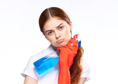 Lastik eldiven giyen temizlikçi kadın deterjan kullanıyor.