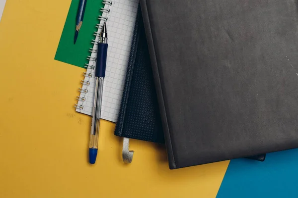 Fekete notepad ceruza színes háttér irodai kellékek — Stock Fotó