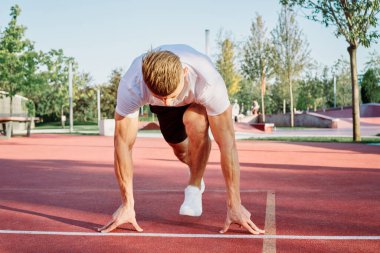 Adam dışarıda oyun sahasında egzersiz yapıyor.