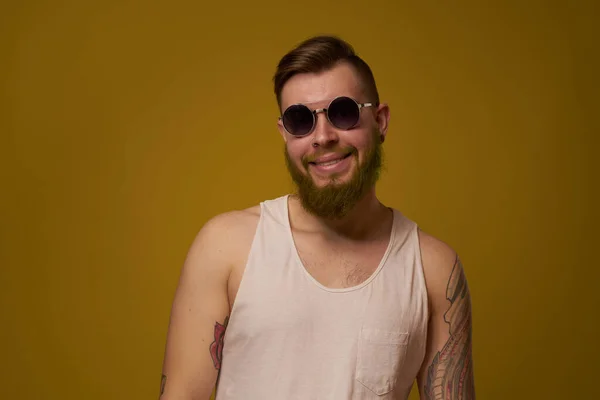 Homem em uma t-shirt branca tatuagens em seus braços moda óculos estilo moderno — Fotografia de Stock