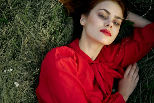 Bella donna in abito rosso si trova sul sole erba natura estiva — Foto Stock