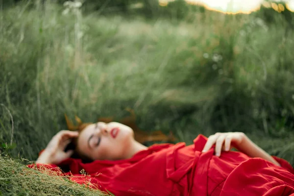 Frau in rotem Kleid liegt im Gras Frischluft Natur Romantik — Stockfoto