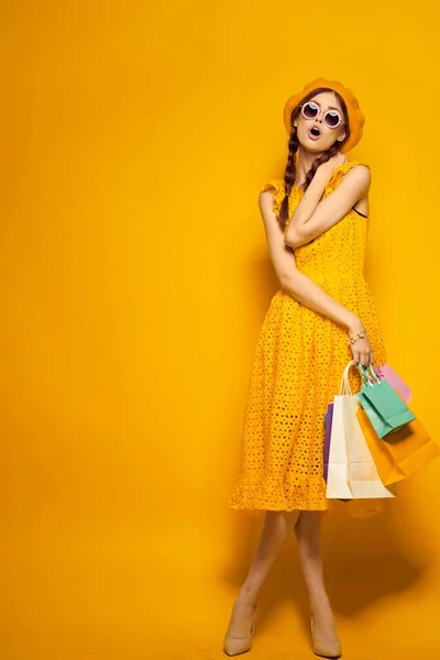 Glimlachende vrouw in een gele hoed Shopaholic mode stijl geïsoleerde achtergrond — Stockfoto