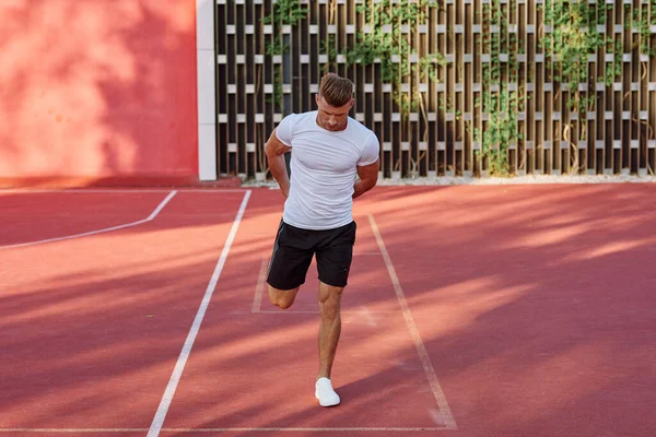 Spor sahası motivasyonunda beyaz tişörtlü adam.