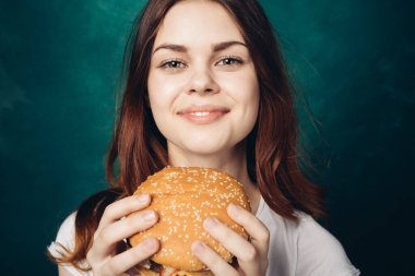 Hamburger yiyen bir kadın.