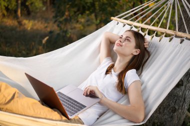Kadınlar dizüstü bilgisayarlı tatil teknolojisiyle köşede yatıyor.