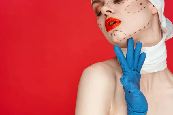顔の輪郭に青い手袋の注射器の女性の肖像画が赤い背景を持ち上げ — ストック写真