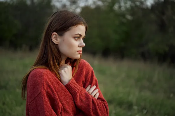 Woman in a red sweater outdoors in a field walk — Stock Photo, Image