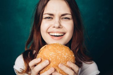 Hamburger yiyen bir kadın.