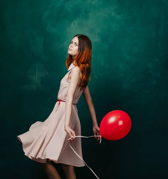 Bonita mujer en vestido rojo globo cumpleaños verde fondo — Foto de Stock