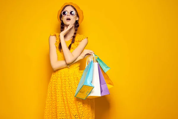 Leende kvinna bär solglasögon poserar shopping mode isolerad bakgrund — Stockfoto