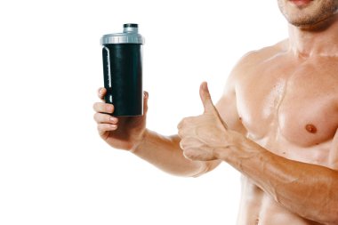 Şişirilmiş gövdesi olan atletik bir adam. Spor tükürüğü şişesi içiyor.