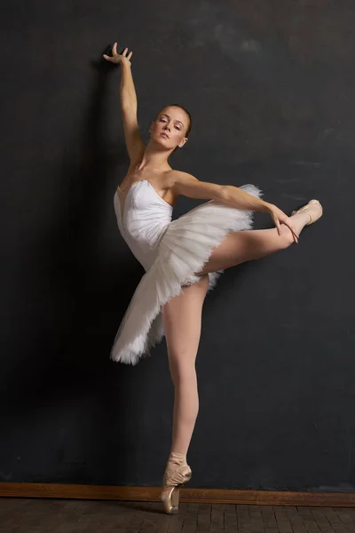 Bailarina de mujer en un tutú blanco danza posando rendimiento fondo oscuro —  Fotos de Stock