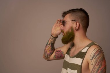 Kollarında vahşi erkek dövmeleri var. Kesilmiş bir yaşam biçimi gibi duruyor.