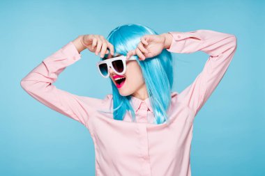 Mavi peruklu güzel kadın güneş gözlüğü takıyor.