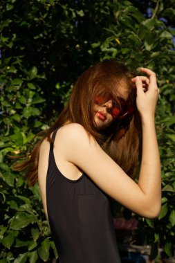 Siyah mayo giyen kadın güneş gözlüğü takıyor.