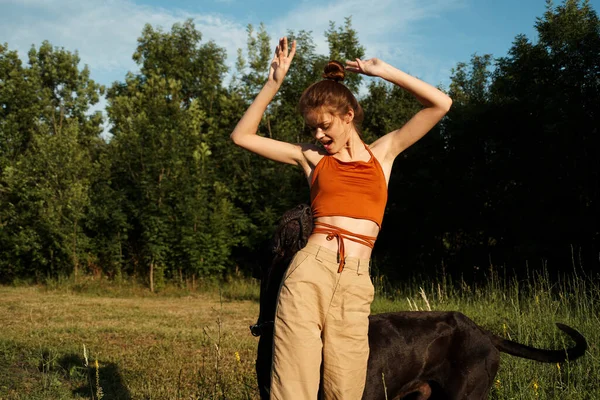 Woman outdoors in the field with dog friendship playing — Stock Photo, Image