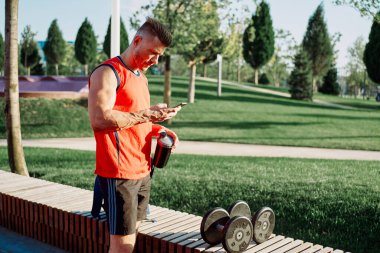 Spor salonunda kırmızı tişörtlü bir sporcu.