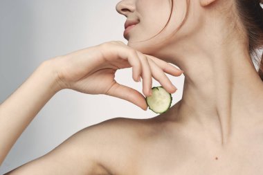 Çıplak omuzlu çekici bir kadın. Salatalık cilt bakımı.