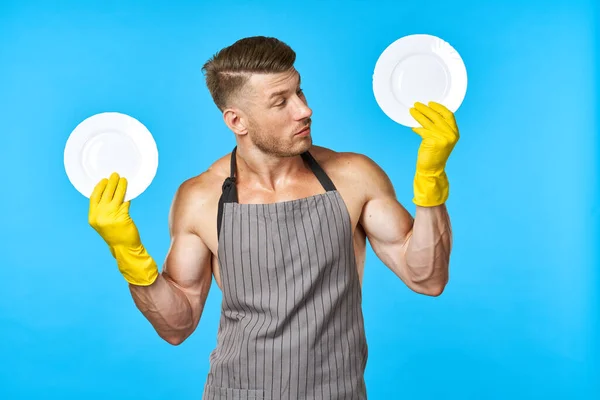 Vrolijke man in schorten afwassen huishoudelijke werk blauwe achtergrond — Stockfoto