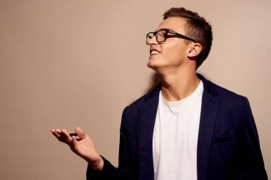 Gözlüklü bej arkaplanlı bir adamın portresi