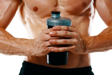 Şişirilmiş gövdesi olan atletik bir adam. Spor tükürüğü şişesi içiyor.