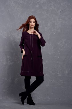 Moda elbiseli kadın stüdyo cazibesiyle poz veriyor.