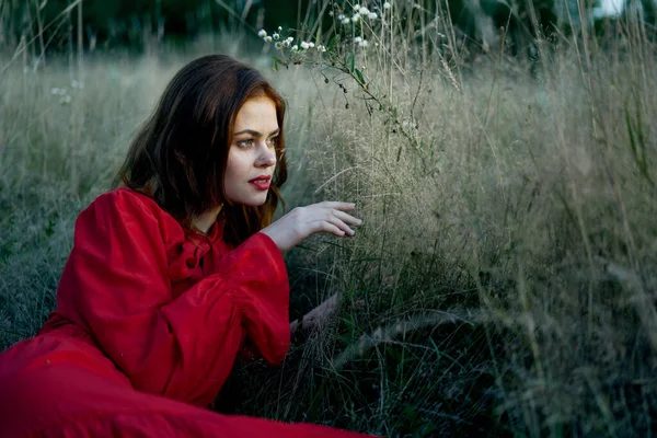 Woman in red dress lies on the grass nature freedom rest — Stock Photo, Image