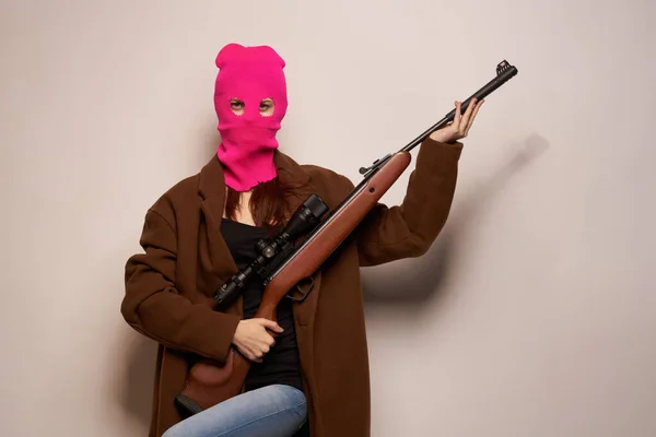 Femme en masque rose avec une arme à la main Lifestyle fond beige — Photo