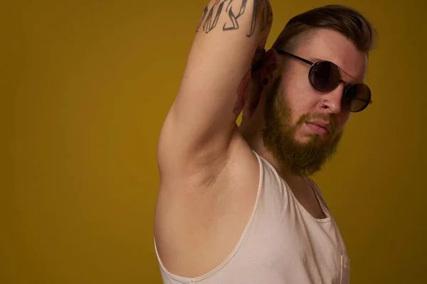 Hombre en una camiseta blanca tatuajes en sus brazos gafas de moda estilo moderno — Foto de Stock